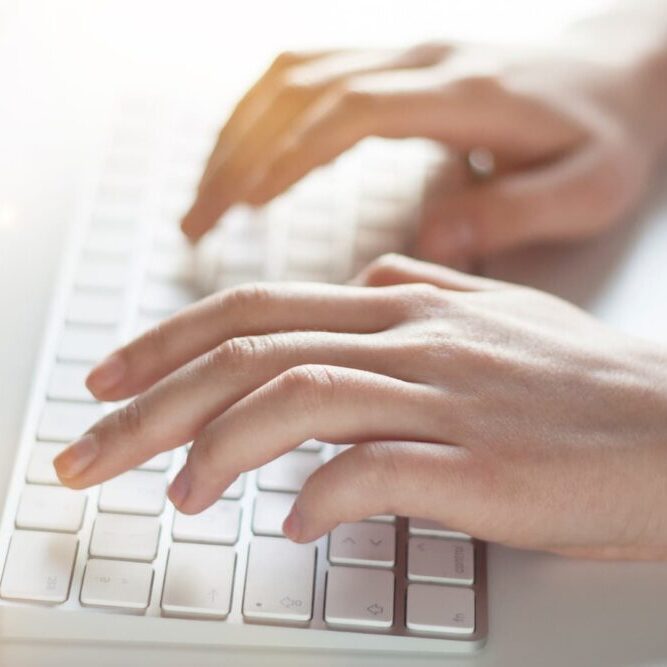 hands on white keyboard typing in content marketing for law firms